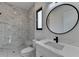 Modern bathroom featuring marble-style tile and a sleek vanity with an oval mirror at 165 Westbrook St, Buford, GA 30518