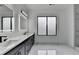 Bright primary bathroom featuring double vanity with marble countertops, sleek black fixtures, and a window at 165 Westbrook St, Buford, GA 30518
