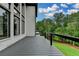 Spacious deck featuring a modern railing system with a view of trees, sky, and landscaped backyard at 165 Westbrook St, Buford, GA 30518