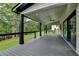 Spacious covered deck with black railings overlooks the lush green lawn and wooded area at 165 Westbrook St, Buford, GA 30518