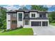 Striking two-story home boasts a modern exterior, multi-car garage, and lush landscaping at 165 Westbrook St, Buford, GA 30518
