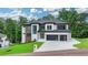 Stunning home featuring unique architectural details, a large driveway, and green surroundings at 165 Westbrook St, Buford, GA 30518