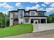 Beautiful two-story home with a modern design, multi-car garage, and landscaped front yard at 165 Westbrook St, Buford, GA 30518