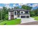 Modern two-story home with striking exterior, a spacious driveway, and a well-kept lawn at 165 Westbrook St, Buford, GA 30518