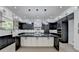 Modern kitchen has a large island with elegant countertops, sleek cabinetry, and high-end stainless steel appliances at 165 Westbrook St, Buford, GA 30518