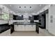 Modern kitchen boasts a large island with marble countertop and sleek black and white cabinetry at 165 Westbrook St, Buford, GA 30518