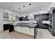 Modern kitchen boasts a large island with marble countertop and sleek black and white cabinetry at 165 Westbrook St, Buford, GA 30518