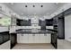 Open kitchen with black and white cabinets, marble countertops, central island with pendant lighting, sink overlooking yard at 165 Westbrook St, Buford, GA 30518