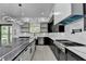Bright kitchen with a large island, modern lighting, and contrasting black and white cabinets at 165 Westbrook St, Buford, GA 30518