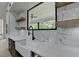 Bright kitchen features a large window over the farmhouse sink with floating shelves at 165 Westbrook St, Buford, GA 30518