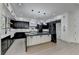 Modern kitchen with black and white cabinetry, marble countertops and backsplash, and a large island at 165 Westbrook St, Buford, GA 30518