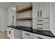 White kitchenette with black hardware, black marble counters, white marble backsplash, and wood shelving at 165 Westbrook St, Buford, GA 30518