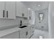 Clean, white laundry room with granite countertops, modern fixtures, and durable tile flooring at 165 Westbrook St, Buford, GA 30518