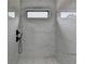 Shower with white marble tiling and black shower head and controls at 165 Westbrook St, Buford, GA 30518