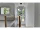 Staircase with wood trim and modern railing, leading to a naturally lit area with black frame windows at 165 Westbrook St, Buford, GA 30518