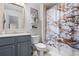 Bathroom with marble shower curtain, gray vanity, and modern shelving combines function and flair at 3013 Walker Hill Way, Marietta, GA 30064
