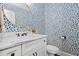 Stylish powder room with designer wallpaper, a marble countertop, and a modern mirror at 3013 Walker Hill Way, Marietta, GA 30064