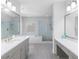 Bathroom featuring dual vanities, glass shower, soaking tub, and modern finishes at 3380 Labrouste Cv, Duluth, GA 30097