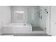 Bathroom featuring soaking tub, glass shower, and modern finishes at 3380 Labrouste Cv, Duluth, GA 30097