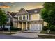 Two-story home with stone accents, blue shutters, a welcoming front porch, and an attached two-car garage at 3380 Labrouste Cv, Duluth, GA 30097