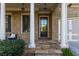 Charming front porch with stone columns and a seating area for relaxing at 3380 Labrouste Cv, Duluth, GA 30097