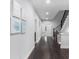 Open hallway with hardwood floors, paintings, and staircase at 3380 Labrouste Cv, Duluth, GA 30097