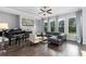 Bright living room featuring hardwood floors, fireplace, piano, and ample natural light from large windows at 3380 Labrouste Cv, Duluth, GA 30097