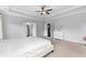 Bright main bedroom boasts neutral carpet, tray ceilings, ceiling fan, and white trim at 3380 Labrouste Cv, Duluth, GA 30097