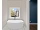 Bright and airy bathroom features a soaking tub under a window with views at 962 Welch Sw St, Atlanta, GA 30310