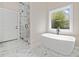 Bright bathroom with a freestanding tub, marble floors, and shower with glass door at 962 Welch Sw St, Atlanta, GA 30310