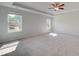 Large bedroom featuring two bright windows, soft carpet, and a ceiling fan at 228 Chiswick Loop, Stockbridge, GA 30281