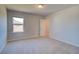 Cozy bedroom with soft carpet, a window, and an open doorway leading to another room at 228 Chiswick Loop, Stockbridge, GA 30281