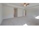 Spacious bedroom featuring soft carpet, ceiling fan, and an open door at 228 Chiswick Loop, Stockbridge, GA 30281