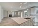 Kitchen island features stainless appliances and an open-concept view to the living room with fireplace at 228 Chiswick Loop, Stockbridge, GA 30281