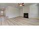 Living room with fireplace, ceiling fan, and an entryway door for easy access to the outside at 228 Chiswick Loop, Stockbridge, GA 30281