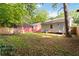 A backyard with a grassy area, a compact air conditioning unit, and a neighboring red house at 286 Booker Sw St, Atlanta, GA 30315