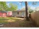 A backyard with a grassy area, a compact air conditioning unit, and a neighboring red house at 286 Booker Sw St, Atlanta, GA 30315