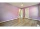 Bedroom featuring wood flooring and light purple walls, two closets, and one doorway at 286 Booker Sw St, Atlanta, GA 30315