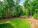 Landscaped backyard featuring mature trees, green lawn, fire pit, and a hammock at 4910 Conover Dr, Atlanta, GA 30338