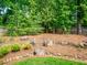 Serene backyard landscape with stone retaining walls and lush trees to create a tranquil outdoor space at 4910 Conover Dr, Atlanta, GA 30338