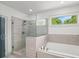 Modern bathroom featuring frameless glass shower, tiled surround, soaking tub, and natural light at 4910 Conover Dr, Atlanta, GA 30338