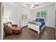 Comfortable bedroom with dark hardwood floors, a window, and a leather chair with an ottoman at 4910 Conover Dr, Atlanta, GA 30338