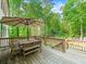 Large outdoor deck with wooden railings and an umbrella-covered dining set overlooking the backyard and trees at 4910 Conover Dr, Atlanta, GA 30338