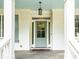 Covered front entryway with view of the glass front door, detailed trim, and blue ceiling at 4910 Conover Dr, Atlanta, GA 30338