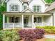 Charming front porch with white columns, gray shutters, glass door and colorful landscaping at 4910 Conover Dr, Atlanta, GA 30338