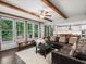 Bright living room with wood beams, a leather sofa, and scenic views from large windows at 4910 Conover Dr, Atlanta, GA 30338