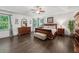 Spacious main bedroom with dark hardwood floors, a ceiling fan, sitting bench, and lots of natural light at 4910 Conover Dr, Atlanta, GA 30338