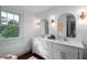 Elegant bathroom with double sinks, modern fixtures, and a bright window with outdoor views at 6104 Floyd St, Covington, GA 30014