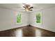 Spacious bedroom with hardwood floors, ceiling fan, and windows offering a view of the outdoors at 6104 Floyd St, Covington, GA 30014