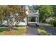 Exterior view of a home with a covered driveway, lush landscaping, and side garage at 6104 Floyd St, Covington, GA 30014